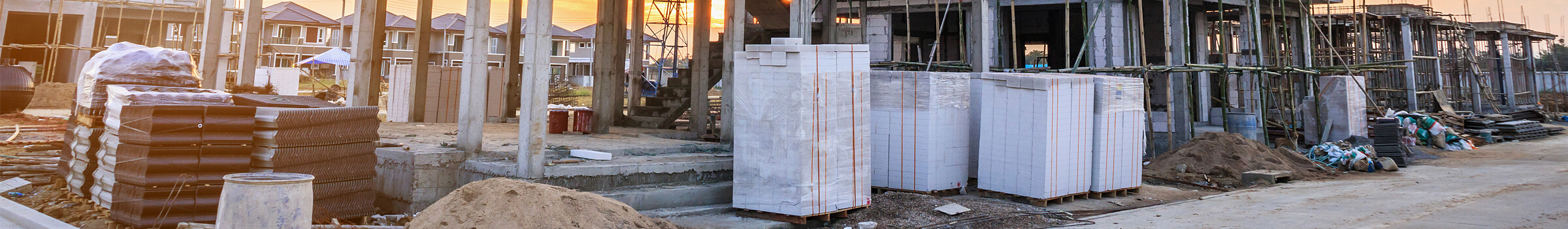 Construction site with building materials, including stacks of bricks and pallets